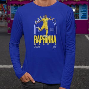 A man wearing a blue long-sleeved shirt with a graphic design featuring a soccer player and text related to the World Cup.