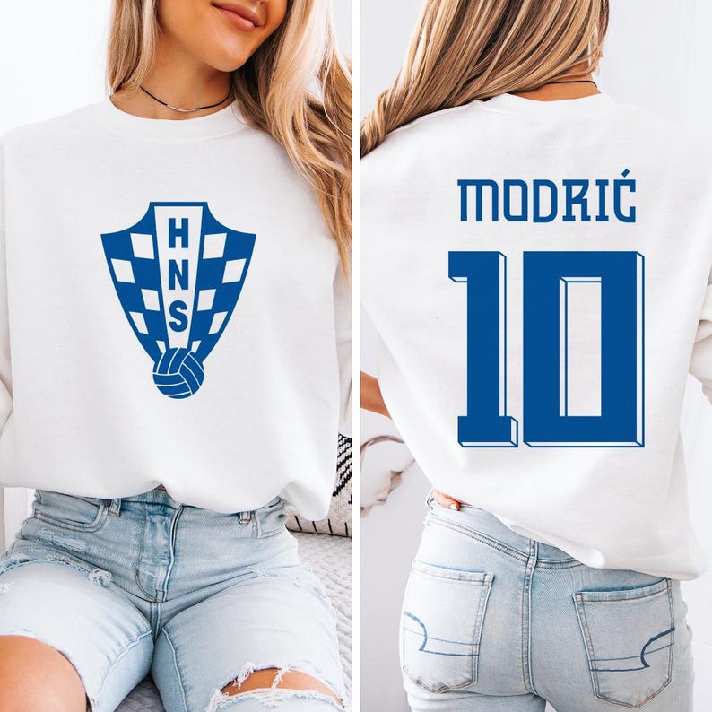 A woman wearing a white sweatshirt with a blue logo and the number 10 on the back.