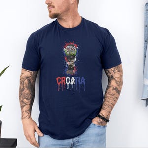 A man wearing a navy blue t-shirt with a graphic of a trophy and the word "Croatia" printed on it.