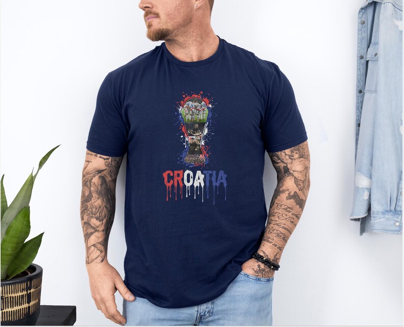 A man wearing a navy blue t-shirt with a graphic of a trophy and the word "Croatia" printed on it.