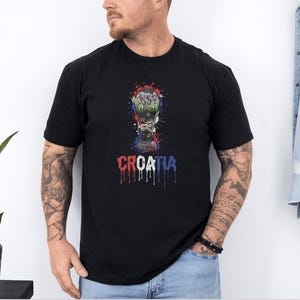 A man wearing a black t-shirt with a graphic design of a trophy and the word "Croatia" printed on it.