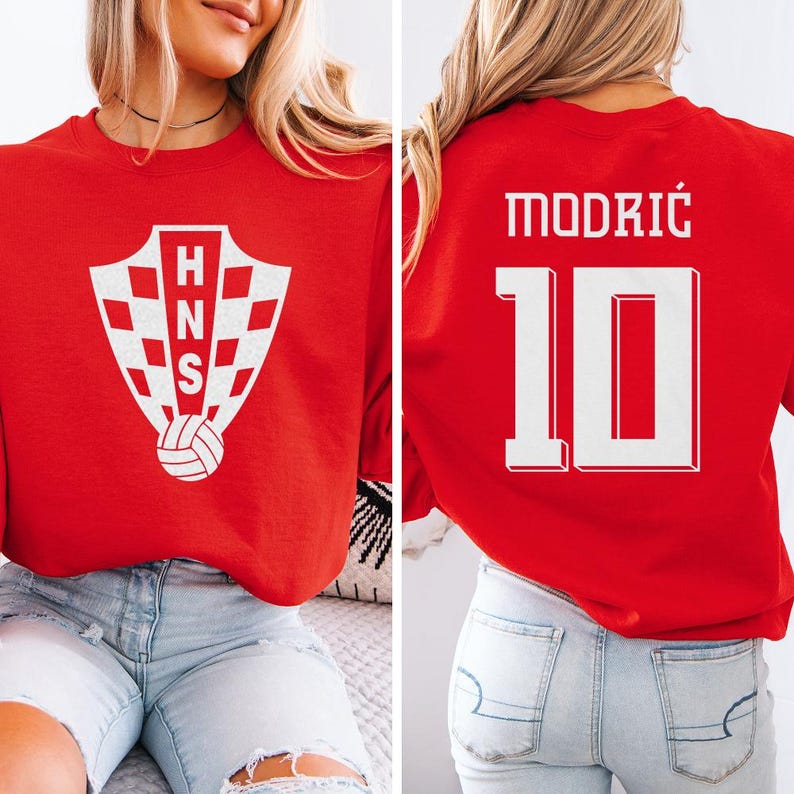 A woman wearing a red shirt with a white crest and the number 10 on it, along with a soccer jersey.