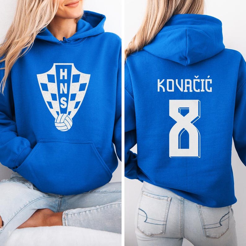 A woman wearing a blue hoodie with a white logo and text on the front and back.