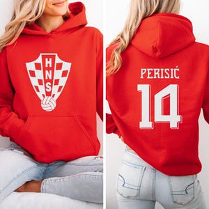 A woman wearing a red hoodie with a white logo and the number 14 on the back.