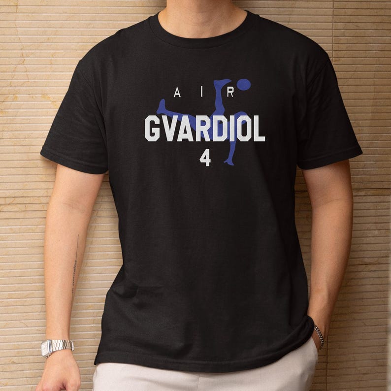 A person wearing a black t-shirt with a graphic design featuring a soccer player and the text "AIR GVARDIOL 4".