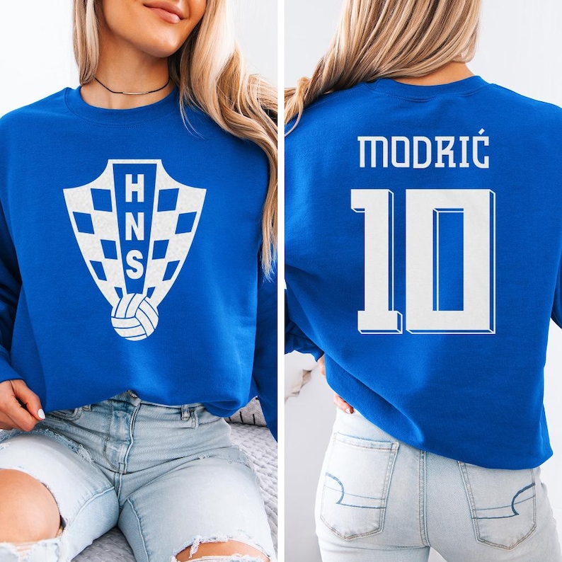 A woman wearing a blue sweatshirt with a white crest and the number 10 on the back.