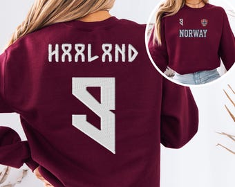 May include: A maroon long-sleeve sweatshirt featuring the text HAALAND and the number 9 in white on the back. The front, shown in an inset, displays the number 9, the Norway flag emblem, and the text NORWAY in white lettering on the chest.