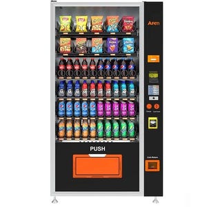 Könnte beinhalten: Ein freistehender Verkaufsautomat mit einem schwarzen und silbernen Rahmen, gefüllt mit Snacks und Getränken. Die Maschine zeigt verschiedene Chips, Limonaden und Flaschengetränke. Das Wort "PUSH" ist auf der Vorderseite sichtbar, zusammen mit einem Münzrückgabefach.