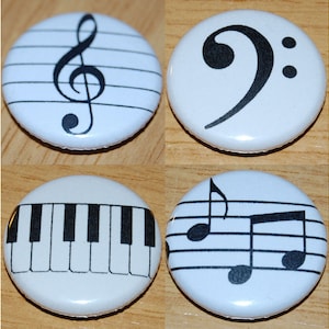 May include: Four white, circular badges displaying musical symbols in black. One shows a treble clef on a stave, another a bass clef, a piano keyboard, and the last has musical notes.