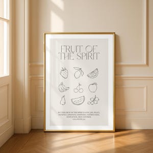 Könnte beinhalten: Ein gerahmter Druck mit goldenem Rahmen. Er zeigt den Text "FRUIT OF THE SPIRIT" und Strichzeichnungen von Früchten. Darunter steht der Text "BUT THE FRUIT OF THE SPIRIT IS LOVE, JOY, PEACE... GALATIANS 5:22". Das Kunstwerk hängt an einer neutralen Wand.