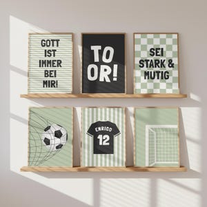 Könnte beinhalten: Sechs gerahmte Drucke auf Holzregalen. Die Drucke zeigen Fußballmotive und Text auf Deutsch. Der Text enthält "GOTT IST IMMER BEI MIR!", "TO OR!" und "SEI STARK & MUTIG". Weitere Drucke zeigen einen Fußball, ein Trikot und ein Tor.