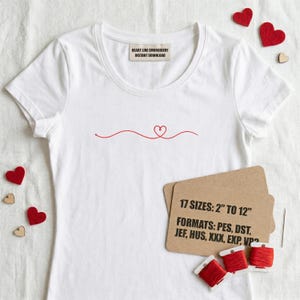 Puede incluir: Camiseta blanca con un diseño de línea de corazón rojo. La camiseta tiene cuello redondo y mangas cortas. El texto "HEART LINE EMBROIDERY INSTANT DOWNLOAD" está impreso en una etiqueta. La imagen también incluye carretes de hilo rojo y una tarjeta con texto.
