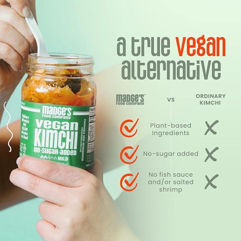 May include: A jar of Mance's Vegan Kimchi, a plant-based alternative. The label is green and white, with the text "vegan kimchi" and "no-sugar-added." The image highlights the product's features: plant-based ingredients, no sugar, and no fish sauce.