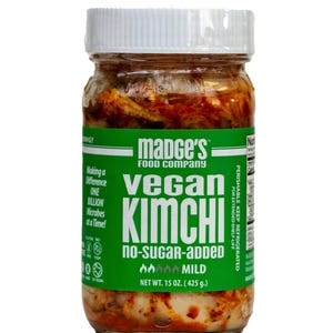 May include: A glass jar of Madge's Vegan Kimchi with a white lid. The jar has a green label with the words "Vegan Kimchi" and "No-Sugar-Added." The net weight is 425 g. The kimchi appears to be a mild variety.