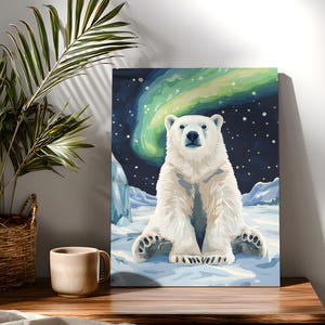 Op de afbeelding: Een rechthoekige wandkunstprint met een witte ijsbeer die op een besneeuwd landschap zit onder een donkere nachtelijke hemel met een levendig groen noorderlicht en verspreide witte sterren in koele blauwe en witte tinten.