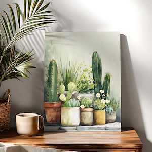 Puede incluir: Pintura a la acuarela de varios cactus y suculentas en macetas de terracota y crema. La obra presenta cactus altos y espinosos, suculentas redondeadas y pequeñas flores blancas, creando una escena serena y natural. La pintura se exhibe sobre una superficie de madera.