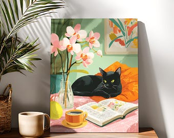 May include: A canvas print depicts a black cat resting on an orange pillow, with an open book and a cup of coffee nearby. A vase of pink orchids and a small painting are in the background. The scene is set on a table with a cup and a basket.