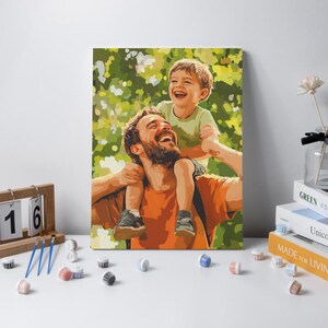 May include: A paint-by-numbers canvas featuring a stylized illustration of a bearded adult carrying a young child on their shoulders. Both figures are smiling against a backdrop of green and yellow foliage. The art uses distinct color blocks.