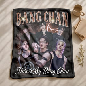 May include: Black fleece blanket with a group of six people and the text "BANG CHAN" in a retro style font. The blanket also has the text "This is My Bang Chan" in a white script font.