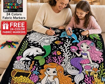 Peut inclure: Une couverture en tissu noir avec des dessins au trait blancs représentant des sirènes, un dauphin et un coffre au trésor, conçue pour être coloriée. L'ensemble comprend une boîte de 24 marqueurs pour tissu avec des capuchons colorés.