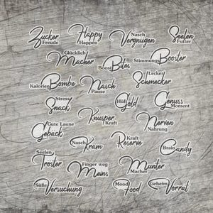 Könnte beinhalten: Eine Ansammlung weißer Schriftwörter auf grauem, strukturiertem Hintergrund. Wörter sind "Happy", "Bites", "Snack", "Gold", "Brain Candy" und "Mood Food". Das Gesamtthema scheint sich auf Essen und Emotionen zu beziehen.