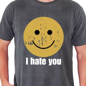 May include: A white ceramic mug with a black handle and the text "But First, Coffee" in a black, bold font. The mug is on a white surface.