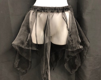 May include: Black, sheer, layered skirt with an elastic waistband. The skirt has a flowing, asymmetrical design with long, draping panels. The fabric appears lightweight and slightly shiny, creating a delicate, ethereal look.