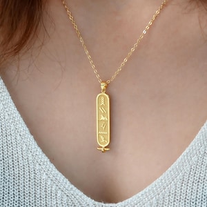 May include: A white ceramic mug with a black handle and the text "But First, Coffee" in a bold, black font. The mug is set against a blurred background, suggesting a cozy setting.