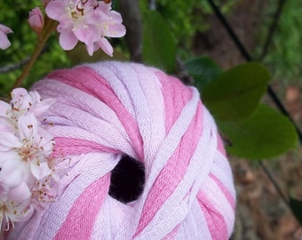 May include: A ball of pink and white yarn with stripes. The yarn is wound into a ball shape and is ready to be used for knitting or crocheting.