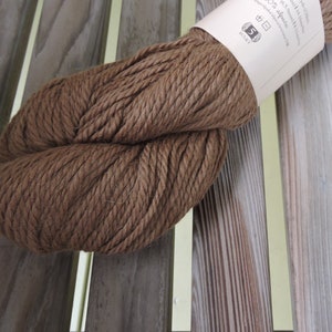 May include: A skein of brown alpaca yarn, labeled "50% alpaca 50% wool" and "Bulky" on the label.