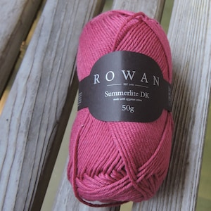 Könnte beinhalten: Eine Knäuel pinkfarbenes Rowan Summerlite DK Garn, hergestellt aus ägyptischer Baumwolle. Das Etikett lautet "Rowan Est. 1978 Summerlite DK made with Egyptian cotton 50g."