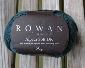 May include: A ball of Rowan Alpaca Soft DK yarn in a deep teal green color. The label reads "ROWAN EST 1978 Alpaca Soft DK made with extra fine, super fine merino wool & baby alpaca 50g".