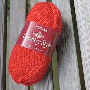 May include: A ball of red yarn labeled "Sirdar Country Style Wool Blend DK".