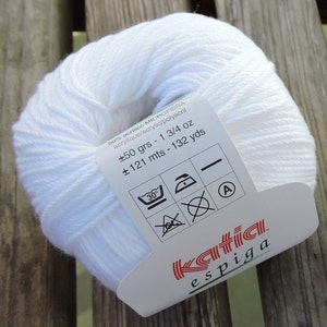 Könnte beinhalten: Weißer Wollknäuel mit dem Etikett "Katia espiga" mit Pflegehinweisen und Details: 50% Mikrofaser-Acryl, 1 3/4 oz, 121 Meter, 132 Yards.