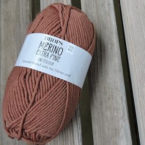 May include: A ball of brown Drops Merino Extra Fine yarn, 100% wool, superwash treated extra fine Merino wool.