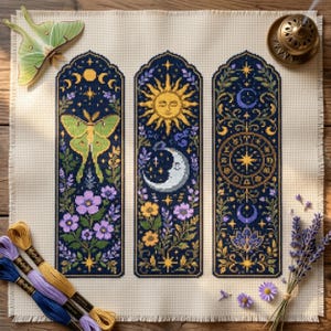 May include: A cross-stitch fabric piece featuring three vertical panels with celestial and botanical motifs, including a luna moth, a sun, a crescent moon, and zodiac symbols in yellow, purple, and green on a dark blue background.