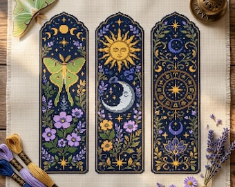 May include: A cross-stitch fabric piece featuring three vertical panels with celestial and botanical motifs, including a luna moth, a sun, a crescent moon, and zodiac symbols in yellow, purple, and green on a dark blue background.