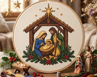 Op de afbeelding: Een ronde houten borduurring met een kruissteekpatroon van een kerststal, inclusief een stal, een ster en figuren in blauw, groen en geel, omringd door hulstbladeren en rode bessen op een witte ondergrond.