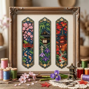 Peut inclure: Une broderie au point de croix encadrée présentant trois panneaux verticaux illustrant des paysages japonais : cerisiers en fleurs avec des carpes koï, un temple avec des iris et une pagode avec des feuilles d'automne, entourée de bobines de fil.