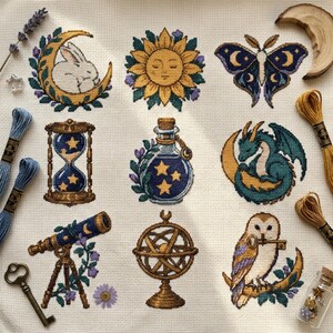 May include: A cross-stitch pattern on white fabric featuring nine motifs: a rabbit on a crescent moon, a sun, a moth, an hourglass, a potion bottle, a dragon, a telescope, an armillary sphere, and an owl holding a key, with embroidery floss.