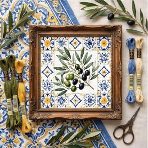 May include: A framed embroidery pattern featuring a central olive branch with green and black olives surrounded by a border of blue, yellow, and white floral tiles. The set includes four skeins of embroidery floss in green, yellow, and blue.