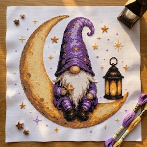 Könnte beinhalten: Eine Kreuzstichstickerei auf weißem Aida-Stoff, die einen Gnom mit langem weißem Bart in einem violetten Hut und Outfit zeigt, der auf einem großen gelben Halbmond sitzt. Das Design enthält eine schwarze Laterne und mehrere kleine goldene Sterne.