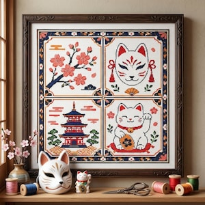 May include: A framed cross-stitch embroidery featuring four quadrants: pink cherry blossoms, a white fox mask, a red and blue pagoda, and a white beckoning cat. The artwork is displayed with a physical fox mask, a cat figurine, and sewing spools.
