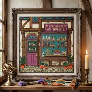 May include: A framed cross-stitch embroidery depicting a storefront labelled The Golden Astrolabe. The design features a purple door, teal walls, shelves filled with bottles and books, and potted plants. The piece is displayed in a wooden frame.