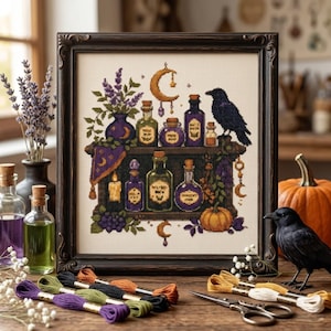 May include: A framed cross-stitch embroidery featuring a dark shelf with purple and green potion bottles, a crescent moon, a black raven, and a pumpkin. The design includes lavender sprigs, grapes, and a candle. Embroidery floss and scissors are nearby.