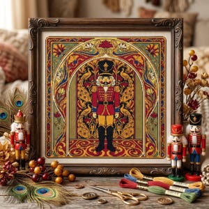 May include: A framed needlepoint art piece featuring a central nutcracker figure in a red uniform, surrounded by an ornate archway with peacock motifs in gold, red, and blue. The artwork is displayed with three small nutcracker figurines.