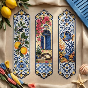 May include: Three vertical cross-stitch patterns on beige fabric. The left features lemons and foliage. The center shows a blue door with pink flowers and a cat. The right depicts a blue fish, coral, and a starfish. Colorful embroidery floss sits below.