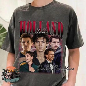 May include: Dark gray t-shirt featuring a collage of Tom Holland images with the word "HOLLAND" in red and the name "Tom" in white. The shirt also has the text "Dolce Paradiso" in cursive.