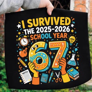 Puede incluir: Camiseta negra con la frase "I Survived The 2025-2026 School Year". El diseño incluye un gran "67" con ilustraciones escolares como un despertador, una manzana, un lápiz y una calculadora. El diseño está sostenido por una persona.