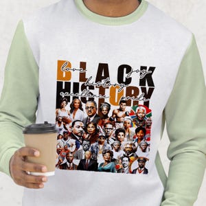 Pu&ograve; includere: Felpa bianca con maniche verde chiaro. Presenta un collage di personaggi storici neri e le parole "Black History" in caratteri marroni e neri. Il testo aggiuntivo recita "love, joy, excellence, pride."